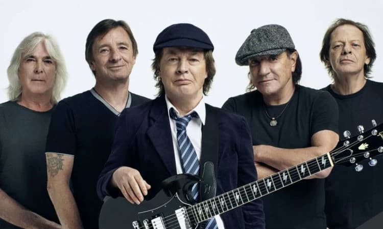 Los cinco integrantes de AC/DC posan con una guitarra ante un fondo claro — la imagen del anuncio de las reediciones