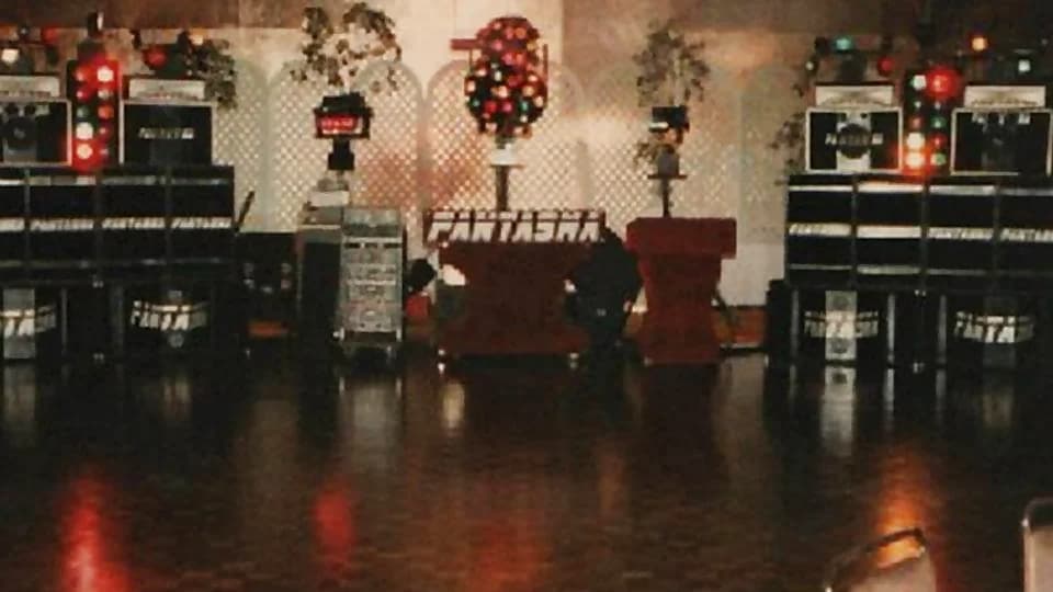Miniteca Fantasma — su cabina rotulada «FANTASMA» en el centro del salón, flanqueada por los dos muros de bafles con el nombre en las cajas, esferas de luces y matas ornamentales (fotografía de archivo)