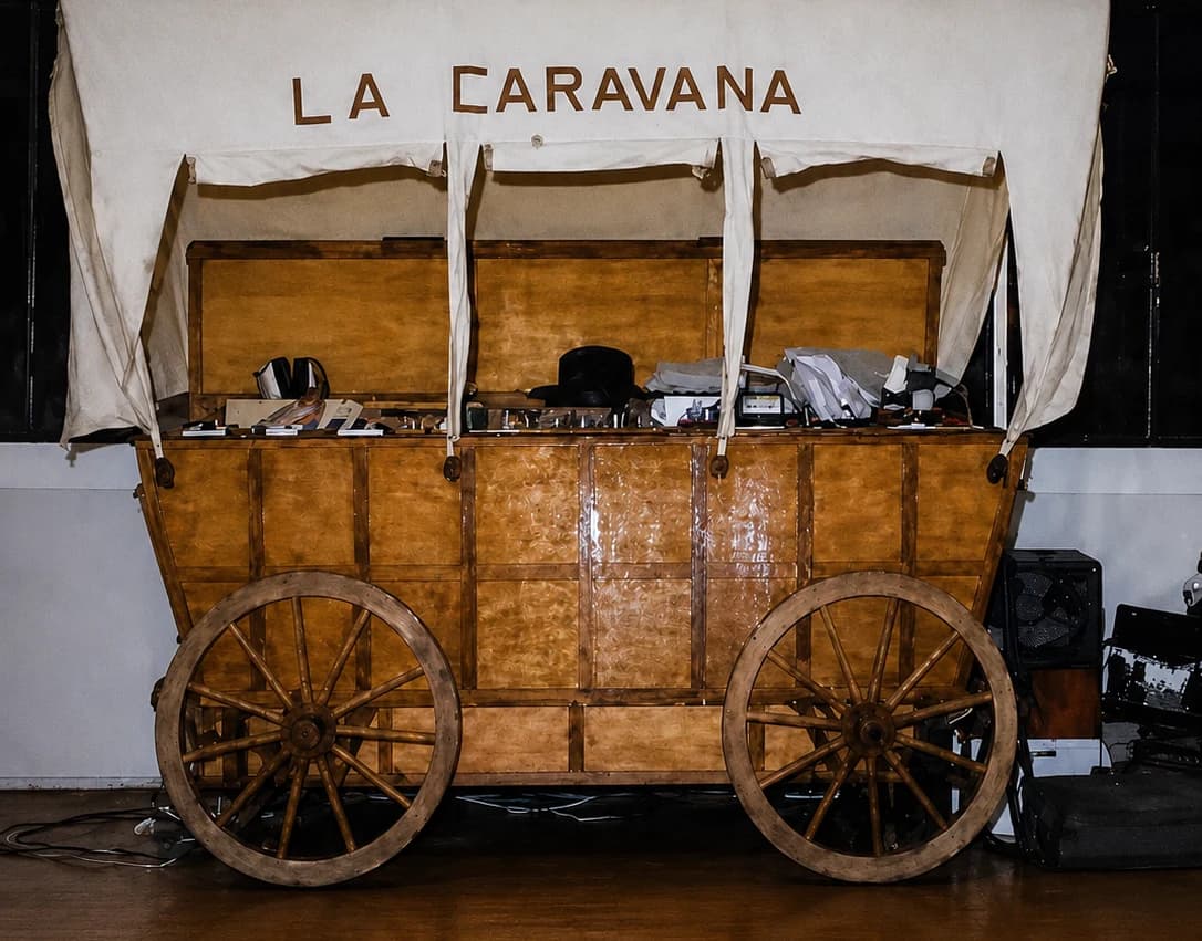 La Caravana — the miniteca's booth built as a replica of a covered Wild West wagon, with “LA CARAVANA” lettered on the canvas and the sound equipment inside it; archive photograph
