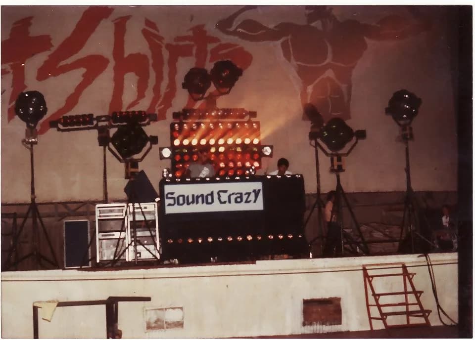 Miniteca Sound Crazy — the full rig on a stage: the console with the “Sound Crazy” sign, the amplifier racks and the spotlights lit on either side