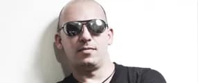 Héctor Patty en retrato apaisado, con la cabeza rapada, lentes de sol espejados y camiseta negra, ante una pared clara Héctor Patty en retrato apaisado, con la cabeza rapada, lentes de sol espejados y camiseta negra, ante una pared clara