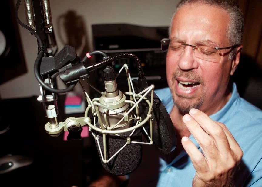 El locutor Alejandro Rhode narrando frente al micrófono de estudio — la voz de los primeros jingles de la miniteca Banana Power El locutor Alejandro Rhode narrando frente al micrófono de estudio — la voz de los primeros jingles de la miniteca Banana Power