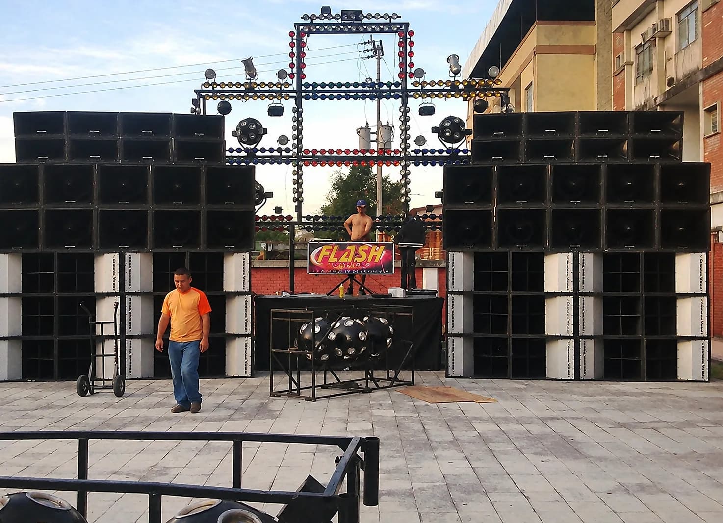 Miniteca Flash Music — dos murallas de cajas de sonido flanqueando un arco de luces con el letrero «Flash», montadas en una plaza, fotografía de archivo Miniteca Flash Music — dos murallas de cajas de sonido flanqueando un arco de luces con el letrero «Flash», montadas en una plaza, fotografía de archivo